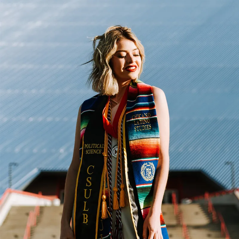University graduates wearing custom embroidered stoles during commencement.