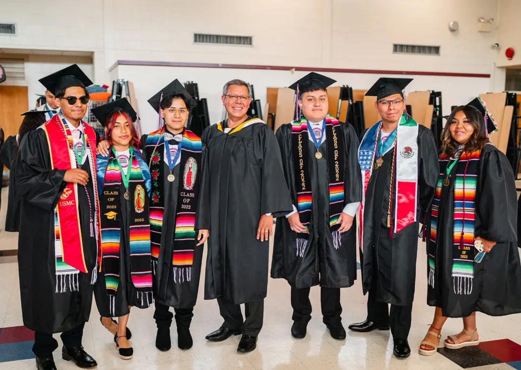 Graduates wearing personalized embroidered graduation stoles during university commencement.