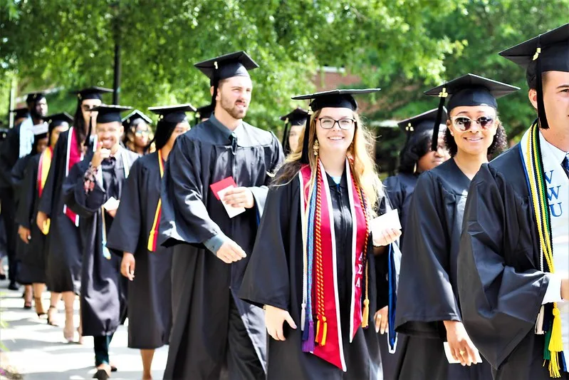 University graduates wearing white stole with red trim graduation